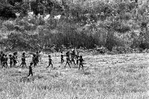 a wounded man is being carried back from the front on the shoulders of his comrades