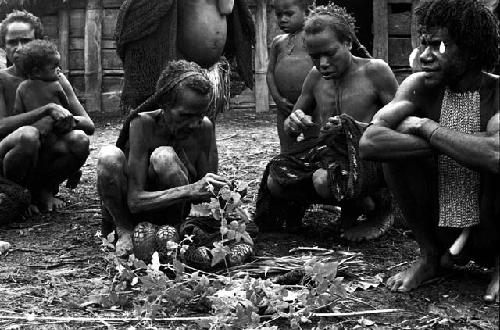 women taking things off their sus and little bits of tobacco to put into the magic bundle