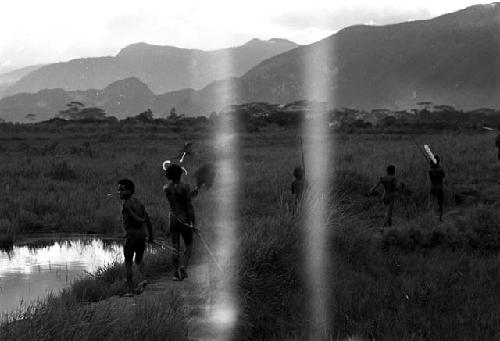 men walking past the Tokolik pond