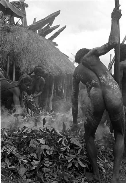 a man helps as the women put stones into haksé