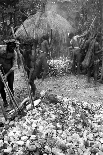 men reaching for hot stones to put into haksé