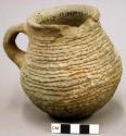 Corrugated pottery jug