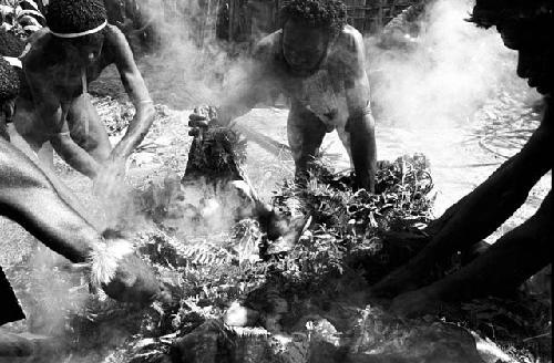 men work arranging the contents of the steam pit