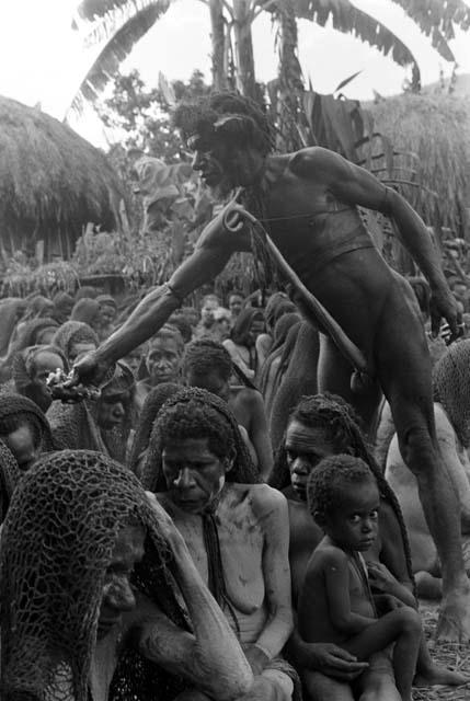 man handing meat out to the women