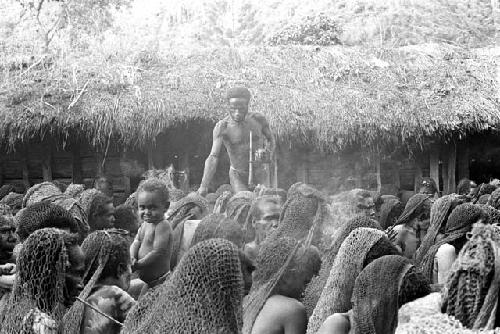 man handing meat out to the women