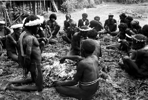 men talking and then eating the pig