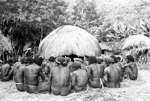 men's group, Wali picks up meat to distribute it