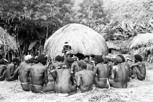 men's group, Wali picks up meat to distribute it