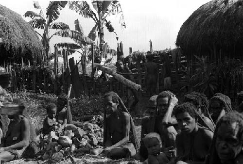 women gathered and a boy who brought in a piece of wood