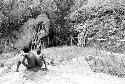 Figures seated on a rock near Lokoparek