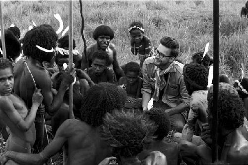 Men and boys talking to Karl Heider