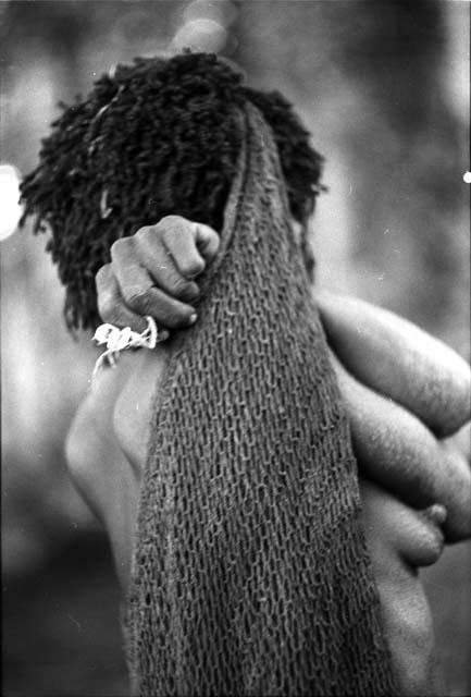 Woman's hands clasped behind her neck