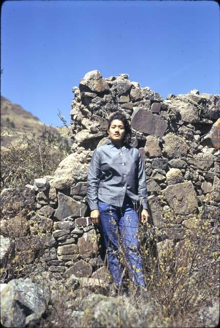 Figure standing in front of stone wall at Pinit (U2343), a hill-top fort