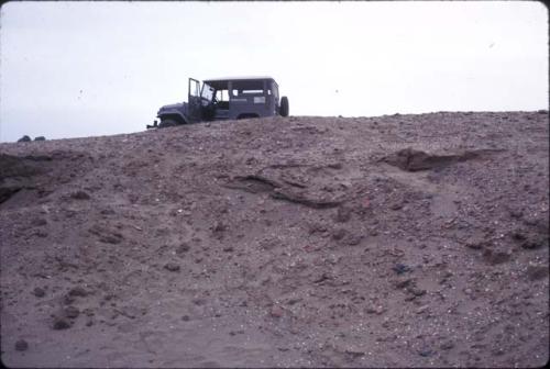 Crew at work excavating test pits in the loose dry sand at preceramic midden site on Alto de Salaverry. Andres Castillo and Michael Moseley shown at work at the site.