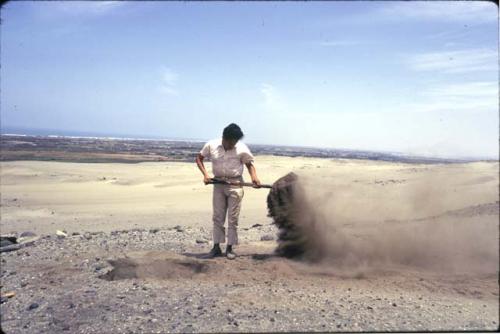 Crew at work excavating test pits in the loose dry sand at preceramic midden site on Alto de Salaverry. Andres Castillo and Michael Moseley shown at work at the site.