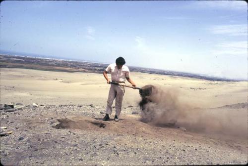 Crew at work excavating test pits in the loose dry sand at preceramic midden site on Alto de Salaverry. Andres Castillo and Michael Moseley shown at work at the site.