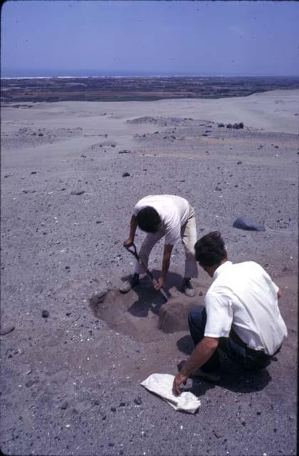 Crew at work excavating test pits in the loose dry sand at preceramic midden site on Alto de Salaverry. Andres Castillo and Michael Moseley shown at work at the site.