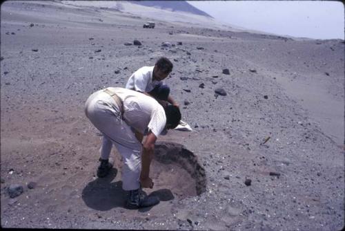 Crew at work excavating test pits in the loose dry sand at preceramic midden site on Alto de Salaverry. Andres Castillo and Michael Moseley shown at work at the site.