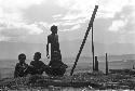 Three boys sitting and one boy standing