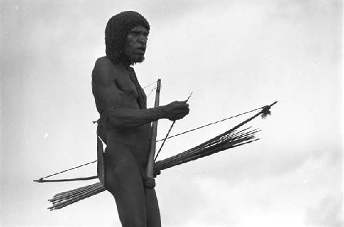 Man standing with bow and arrows