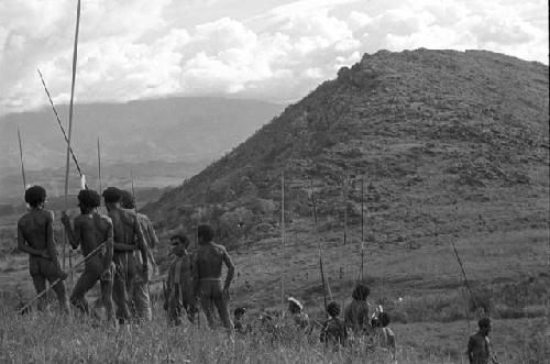 Men standing with hill in the distance