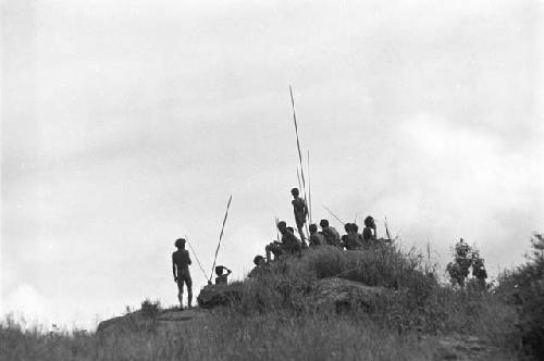 Men with poles in field