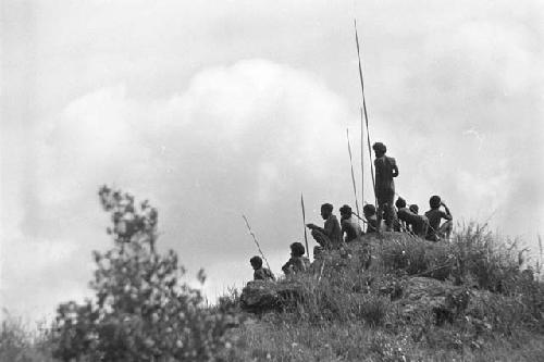Men with poles in field