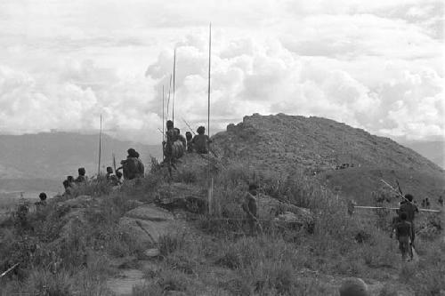 Men in field with poles