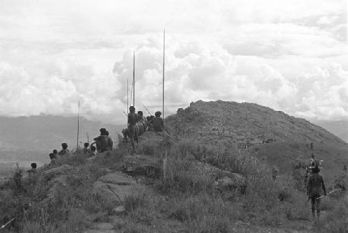 Men in field with poles