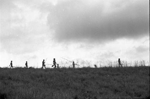 Men in the field with poles