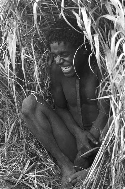 Man laying in grass, laughing