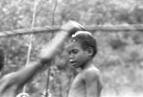 Blurred image of two boys; one throwing a spear