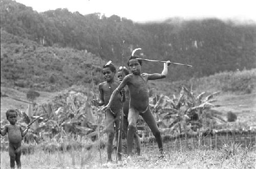 Young boys throwing spears