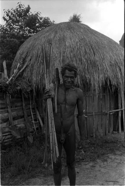 Man carrying an axe and a bow and arrow