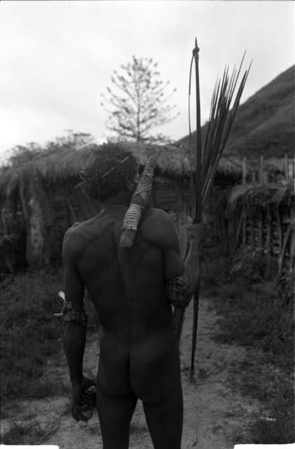 Man carrying an axe and a bow and arrow