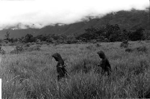 2 women walking towards the field