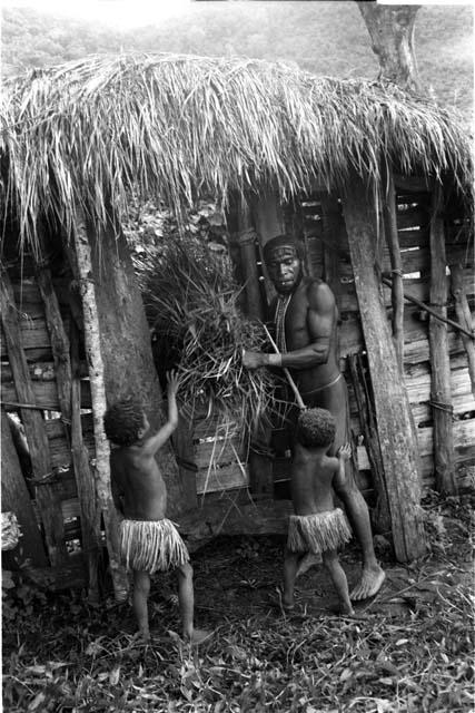 Apeori helps little girls take thatch through sili