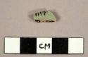 Body sherd, white glaze one side, grey glaze, with black design on other.