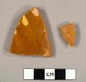 Body sherd; brown glaze with trace of yellow design (a and b).