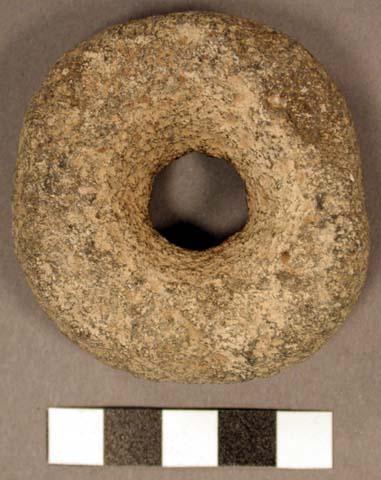 Stone ring. complete, discoidal. hole in center or ring (1.6 cm. dia.) periphery