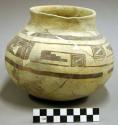 Ceramic jar, black on yellow exterior, flared neck, round base, reconstructed