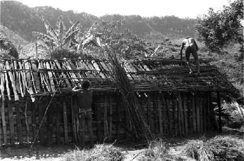 Men building hunu roof