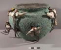 Fetish pot, encrusted with crushed turquoise, with 8 quadruped fetishes attached with leather ties through holes made in the pot for this purpose