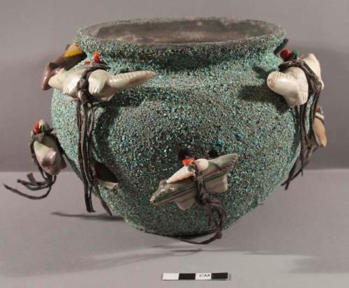 Fetish pot, encrusted with crushed turquoise, with 8 quadruped fetishes attached with leather ties through holes made in the pot for this purpose