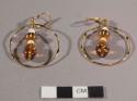 Pierced earrings of gold-colored metal circles with amber-colored glass beads and mastodon ivory beads