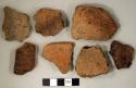 Coarse earthenware body and rim sherds, some incised, some cord impressed, some rocker dentate, some punctate or impressed