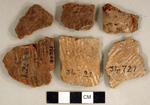 Coarse earthenware body sherds, cord impressed, some with iron residue; unidentified iron fragment