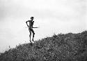 Man jumping on the hill in a taunting gesture toward the enemy