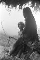 Child looking at sitting woman under the oléa up behind Homaklep and Wuperainma