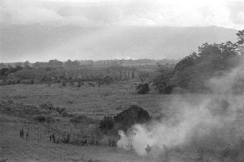 Group of men in the distance with smoke